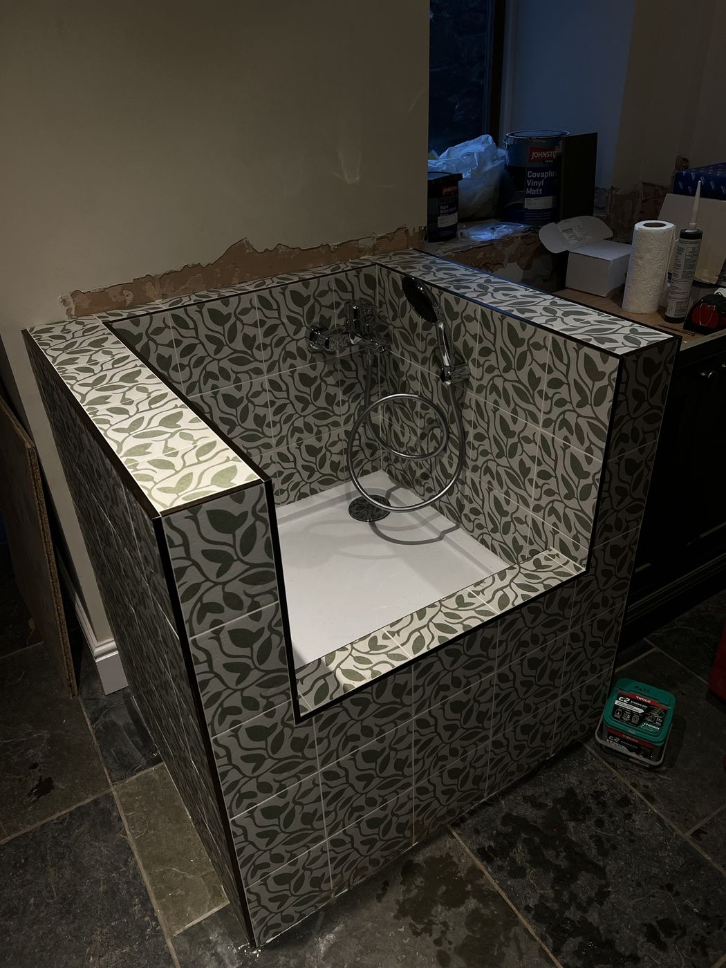 Finished dog shower tiled in a green leaf pattern